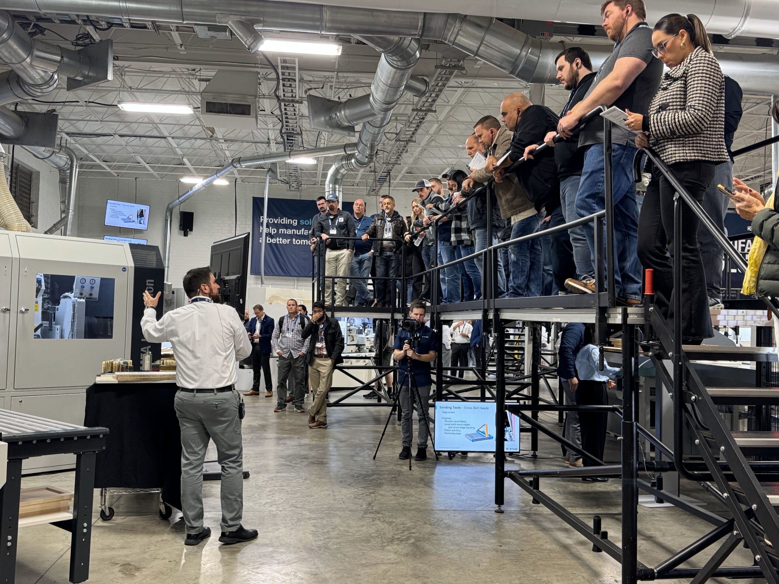 A Stiles Machinery representative demonstrates the latest in sanding capabilities to an audience in their showroom.